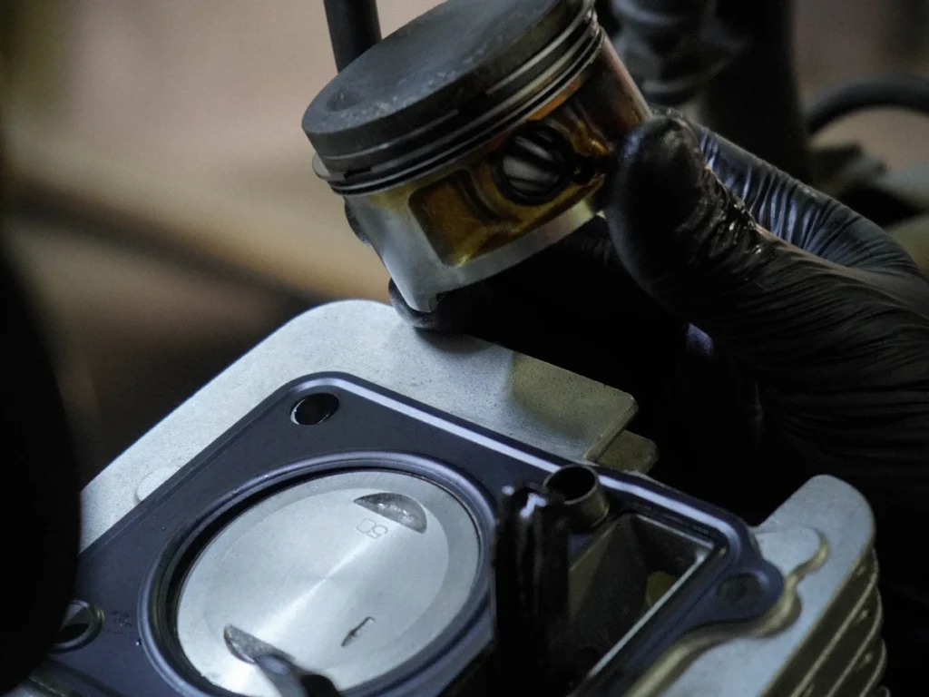 Mekanik memegang piston di atas blok silinder mesin